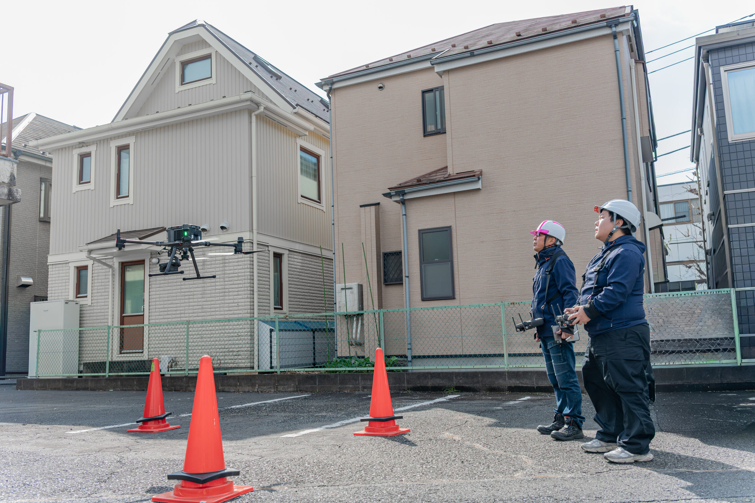 操縦者2名とドローンによる外壁調査の様子